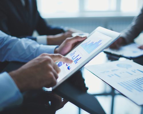 Image of businessperson pointing at document in touchpad at meeting