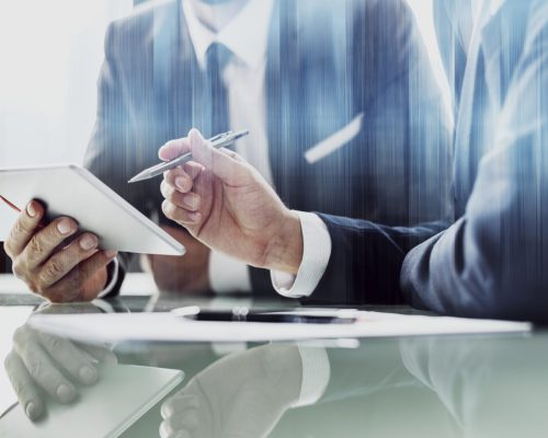 Corporate businessmen working on tablet at office